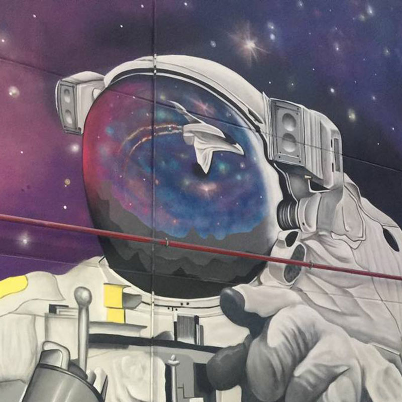 Graffiti de astronauta en el espacio, en la escafandra se refleja la nave