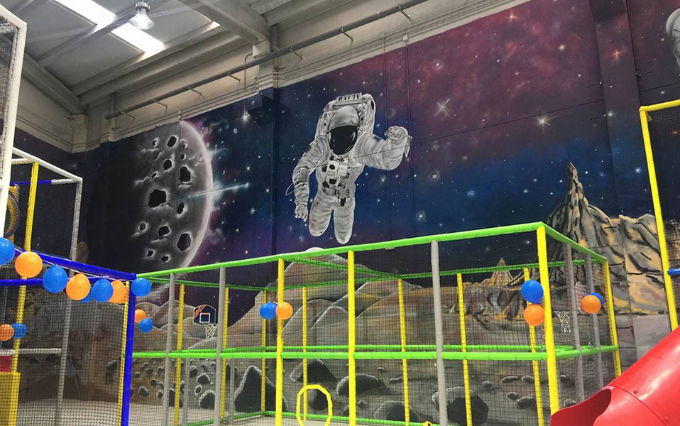 Graffiti de astronauta flotando con la luna de fondo