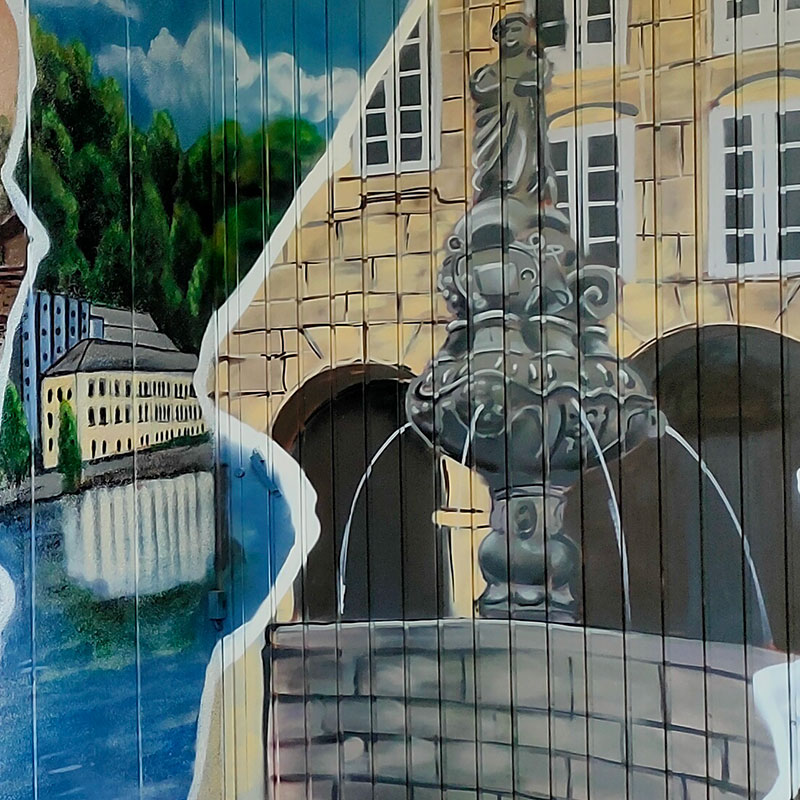Detalle del graffiti en un garaje, vemos el Balneario de Lugo y la fuente de San Vicente echando agua