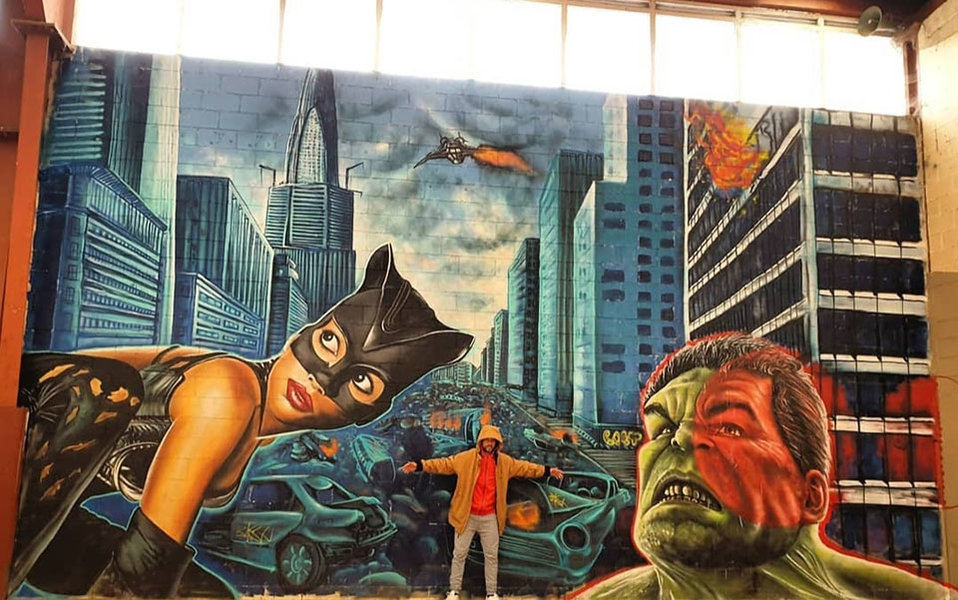 Diego AS posa con su graffiti entre Catwoman y Hulk