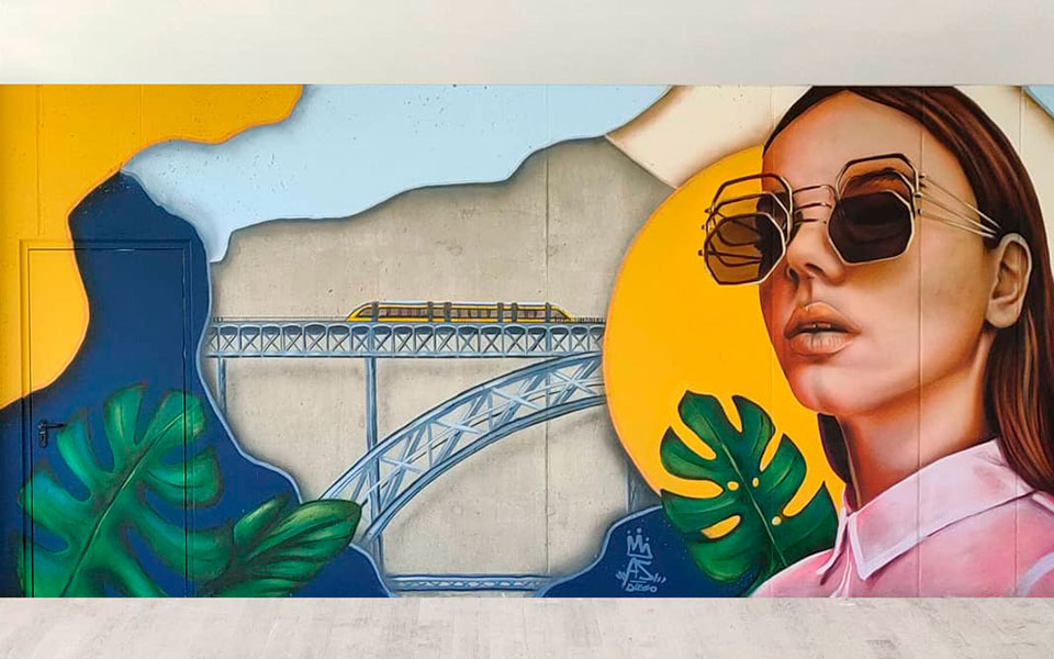Grffiti del puente de Oporto de fondo con el tren y una chica al frente con 3 gafas de sol unas sobre otras