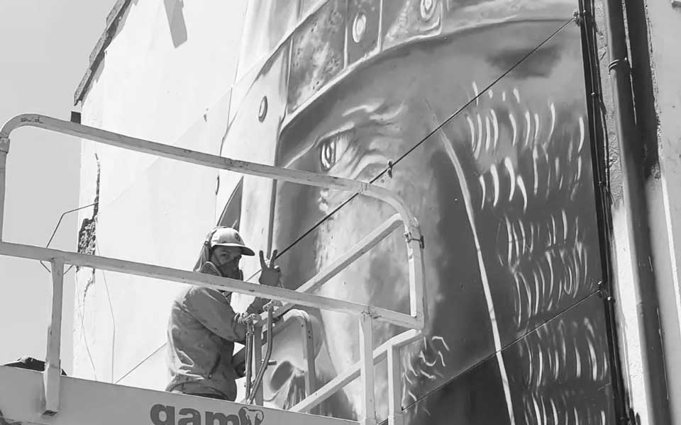 Diego AS subido en la grua pintando mural de El Cid