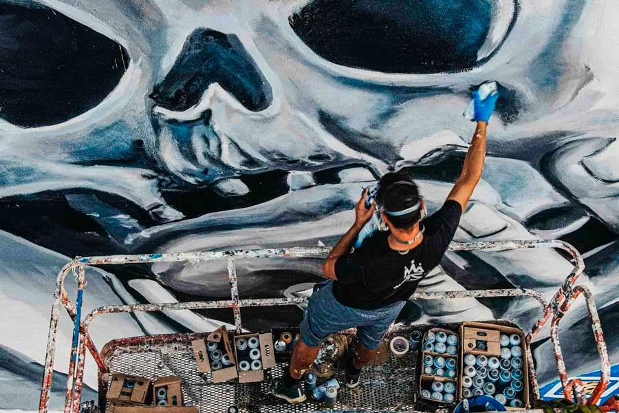 Diego AS pintando el graffiti subido a una grua